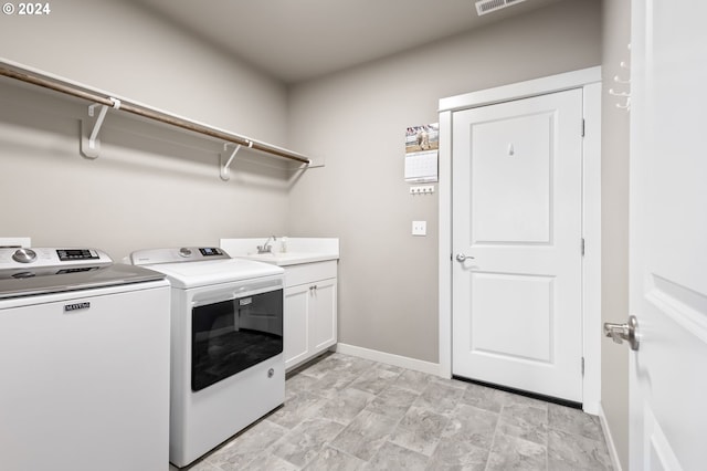 laundry room with sink, independent washer and dryer, and cabinets