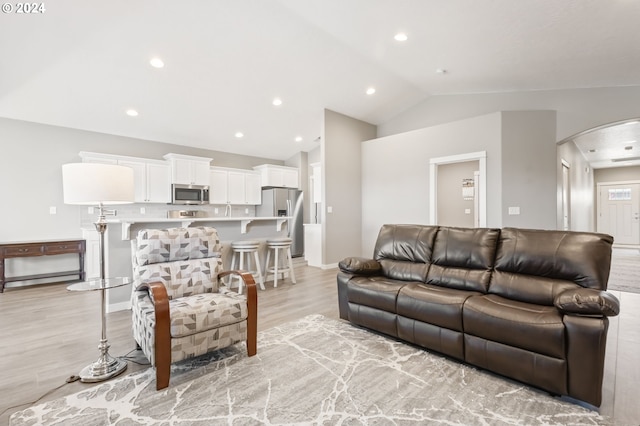 living room with lofted ceiling and light wood-type flooring