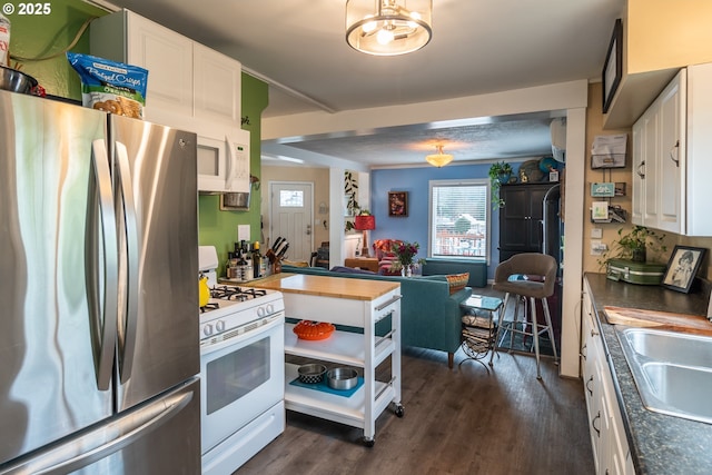 kitchen featuring white cabinetry, dark hardwood / wood-style flooring, white appliances, and sink