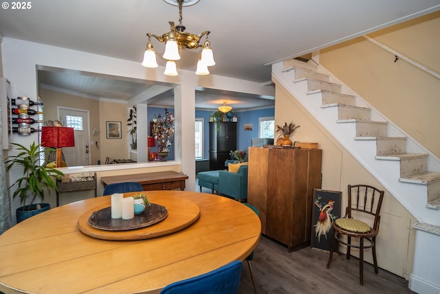 dining space with dark hardwood / wood-style floors, an inviting chandelier, and ornamental molding