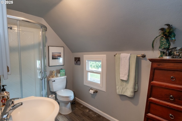 bathroom featuring sink, vaulted ceiling, toilet, a shower with door, and hardwood / wood-style flooring