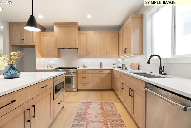 kitchen featuring a sink, stainless steel appliances, light countertops, and light brown cabinetry