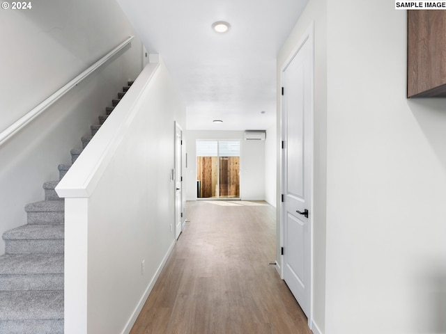 hallway featuring light hardwood / wood-style floors and a wall mounted air conditioner