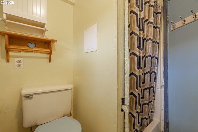 bathroom with shower / bath combo with shower curtain and toilet