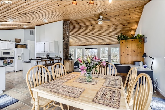 tiled dining area with high vaulted ceiling, wooden ceiling, and ceiling fan