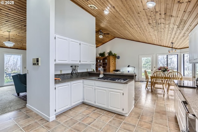 kitchen with kitchen peninsula, stainless steel gas cooktop, white cabinetry, dark stone countertops, and wooden ceiling