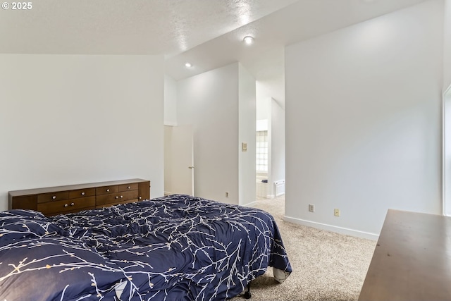 carpeted bedroom with lofted ceiling, ensuite bathroom, and a textured ceiling