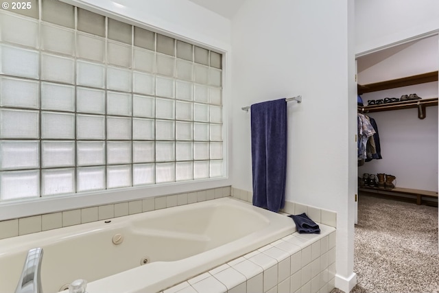 bathroom with a healthy amount of sunlight and tiled bath