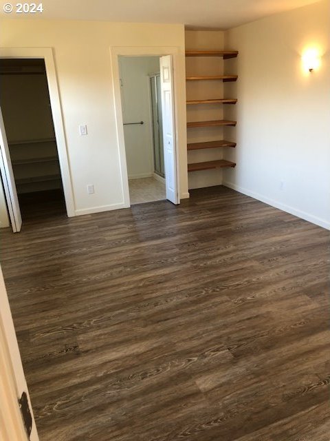 unfurnished room with dark wood-type flooring