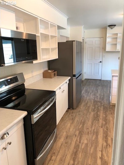 kitchen featuring light wood-type flooring, appliances with stainless steel finishes, and white cabinetry