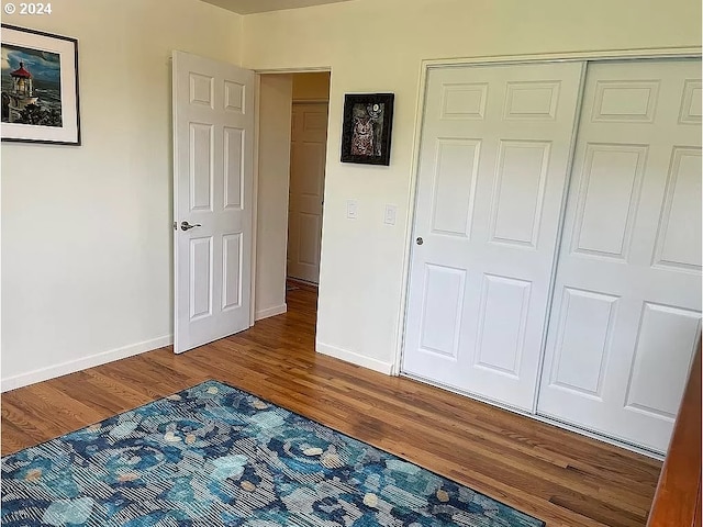 unfurnished bedroom featuring a closet and hardwood / wood-style flooring