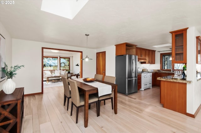 dining area featuring a skylight and light hardwood / wood-style flooring