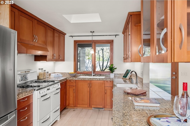 kitchen with pendant lighting, sink, stainless steel fridge, custom exhaust hood, and double oven range