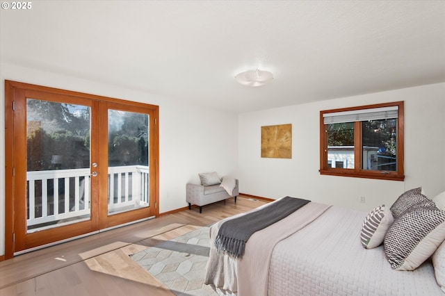 bedroom featuring french doors, light hardwood / wood-style flooring, and access to outside