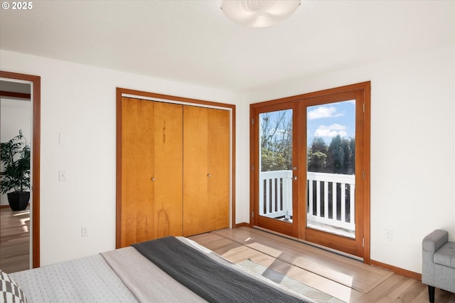 bedroom with hardwood / wood-style floors, access to outside, a closet, and french doors