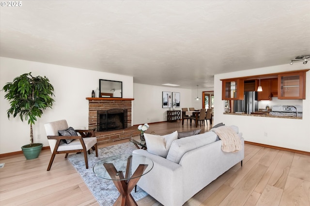 living room featuring a brick fireplace and light wood-type flooring