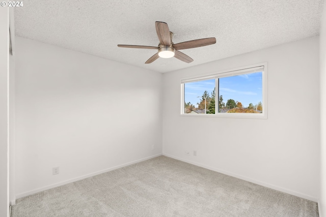 unfurnished room with light carpet, ceiling fan, and a textured ceiling