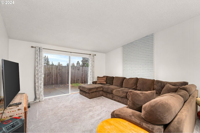 living room featuring carpet flooring, a textured ceiling, and vaulted ceiling