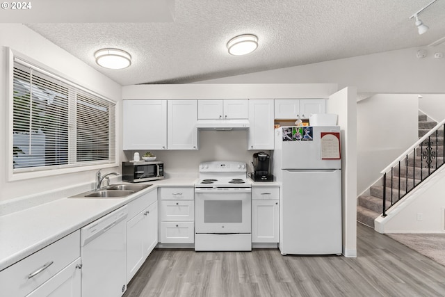 kitchen with white appliances, light hardwood / wood-style flooring, vaulted ceiling, and sink