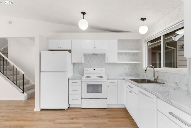 kitchen with white appliances, vaulted ceiling, sink, pendant lighting, and white cabinets