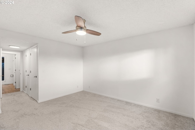 carpeted empty room with ceiling fan and a textured ceiling