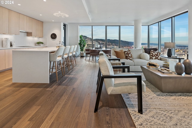 living area with recessed lighting, floor to ceiling windows, and wood finished floors