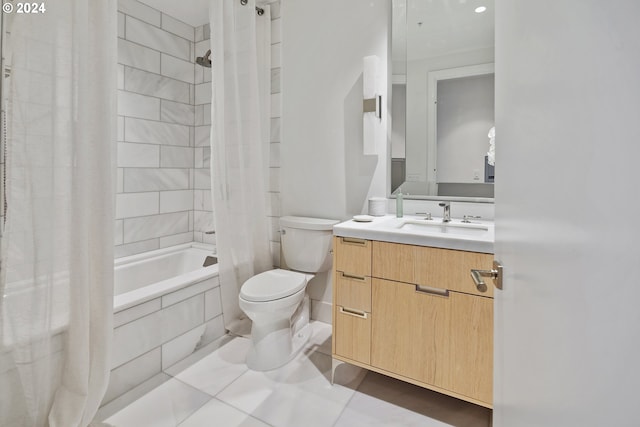 bathroom featuring tile patterned flooring, tiled shower / bath, toilet, and vanity