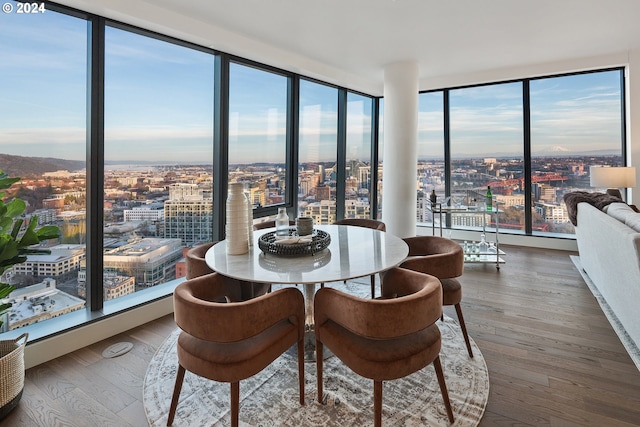 dining area featuring wood-type flooring and a city view