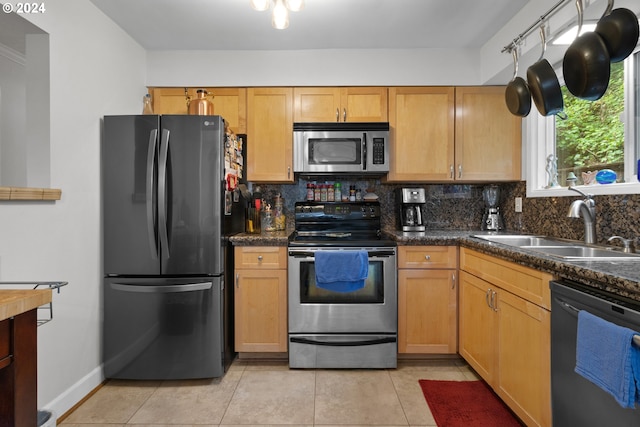 kitchen with sink, appliances with stainless steel finishes, tasteful backsplash, and light tile floors