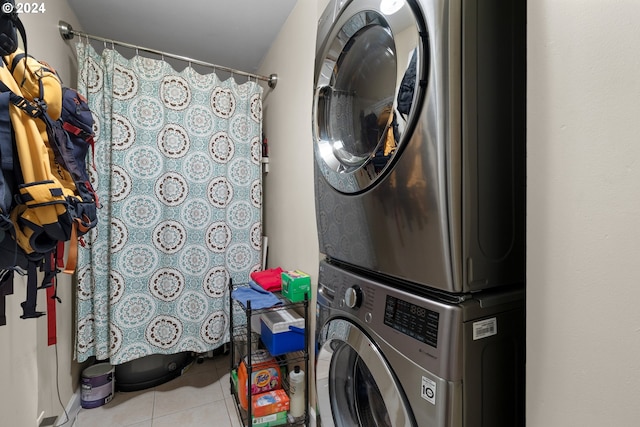 clothes washing area featuring tile floors and stacked washer / drying machine