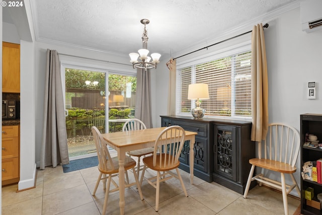 tiled dining space featuring a textured ceiling, a wall mounted AC, crown molding, and an inviting chandelier