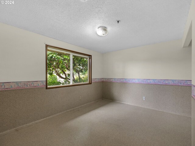 unfurnished room featuring a textured ceiling