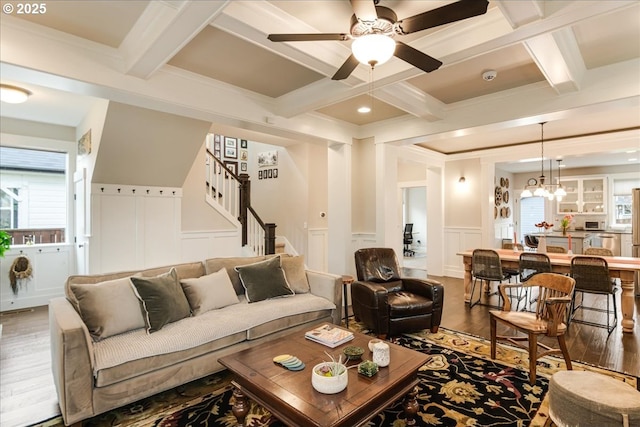 living area with a decorative wall, beamed ceiling, and stairs