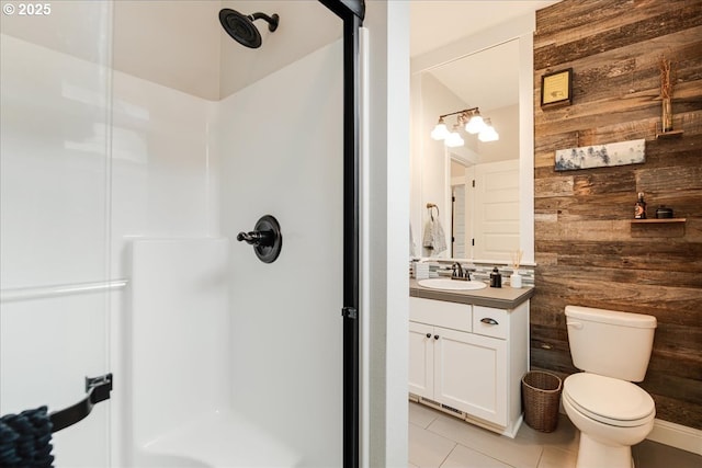 full bathroom featuring wooden walls, a shower stall, toilet, tile patterned floors, and vanity