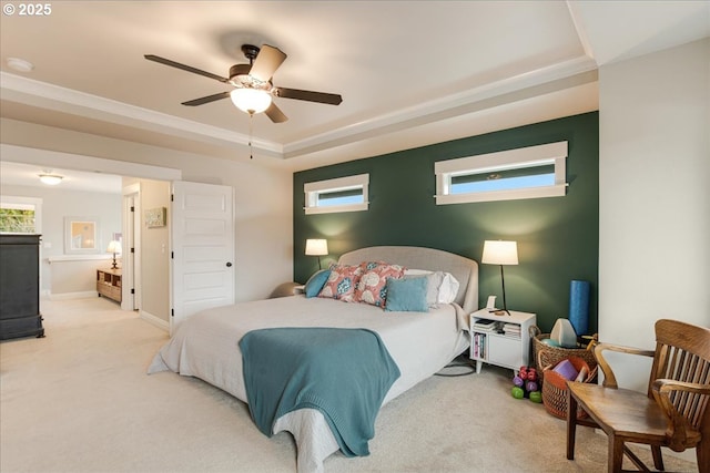 bedroom featuring a raised ceiling, a ceiling fan, baseboards, and carpet floors