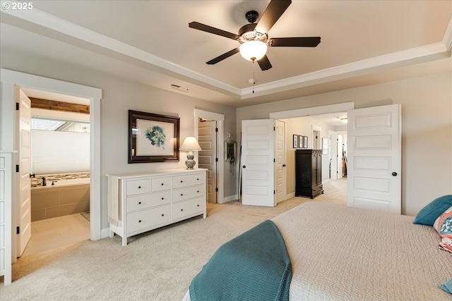 bedroom with light carpet, connected bathroom, baseboards, and a tray ceiling