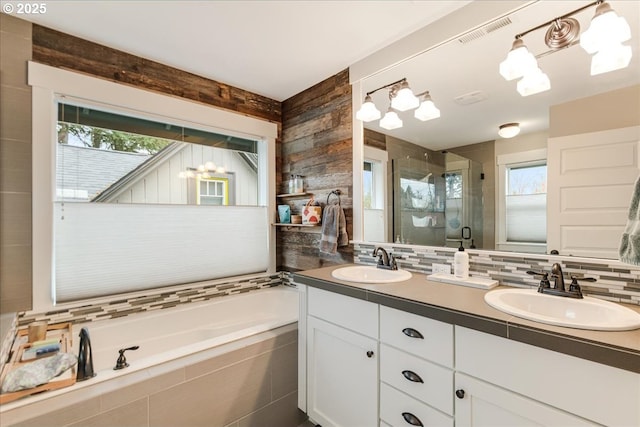 full bathroom with visible vents, a shower stall, decorative backsplash, and a sink