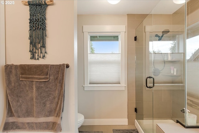 full bath featuring baseboards, toilet, and a shower stall