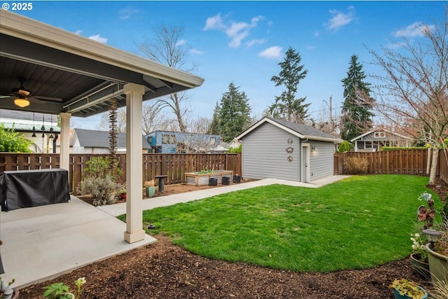 view of yard with a fenced backyard, a ceiling fan, an outdoor structure, and a garden