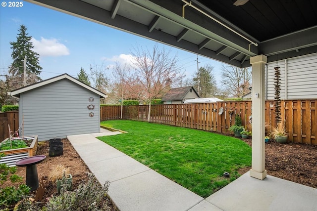 view of yard with a vegetable garden, an outbuilding, and a fenced backyard