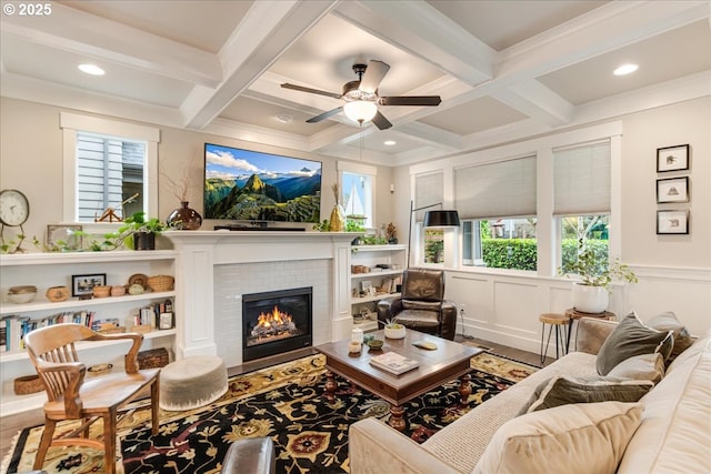 living area featuring beam ceiling, a healthy amount of sunlight, and coffered ceiling