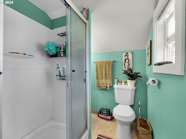 bathroom with a shower with door, toilet, and lofted ceiling