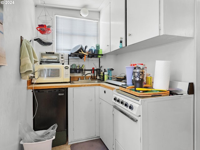 kitchen with dishwashing machine, refrigerator, sink, and white cabinetry