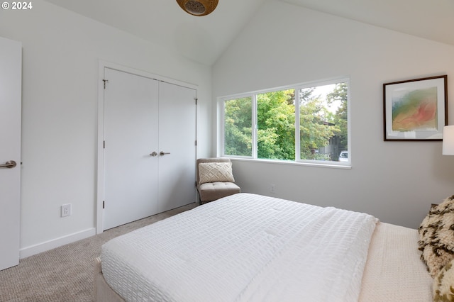 carpeted bedroom featuring lofted ceiling and a closet