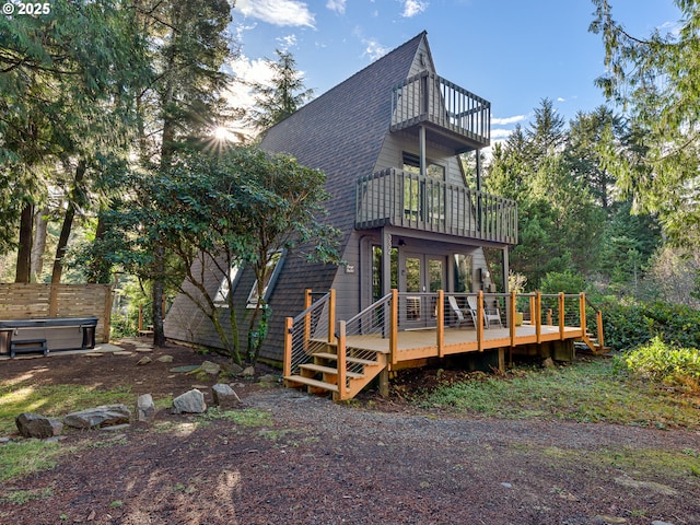 rear view of house with a balcony and a wooden deck