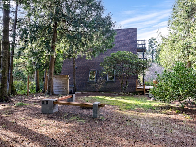 back of house featuring a balcony and a deck