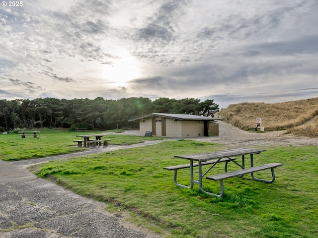 view of property's community with a lawn and an outbuilding