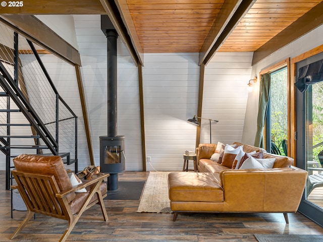 living room with wooden walls, a wood stove, dark wood-type flooring, and wood ceiling