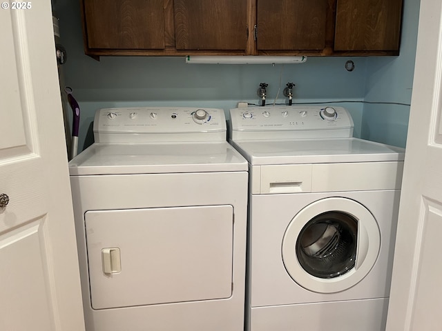 laundry room featuring washer and dryer and cabinets