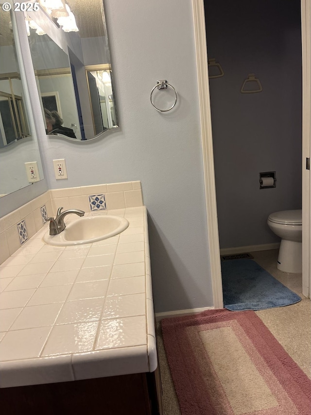 bathroom featuring vanity and toilet